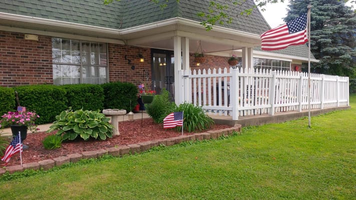 Front entrance with flowers and American flags