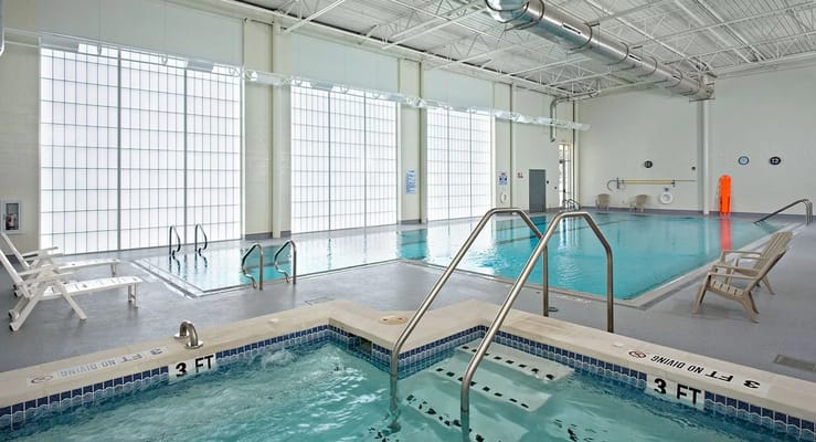 Indoor pool area with large windows and Jacuzzi