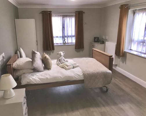 A well-furnished private resident room with bed and decor