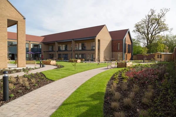 Exterior view of a care home facility with landscaped gardens