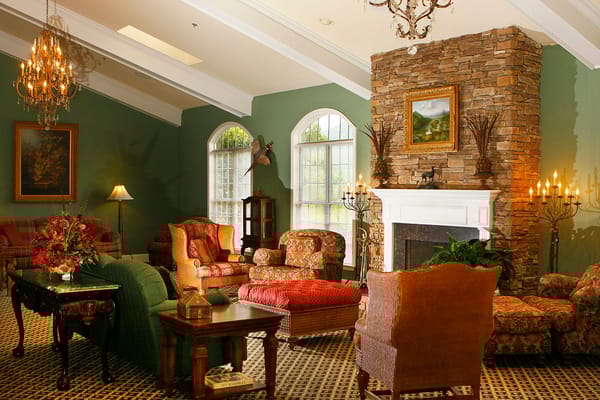 Cozy common area with floral furniture and a stone fireplace