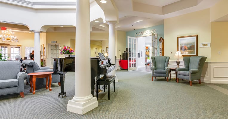 Bright common area with seating and a piano