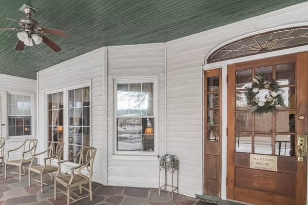 Covered porch with seating and front door entrance