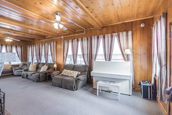Bright common area with comfortable seating and a piano