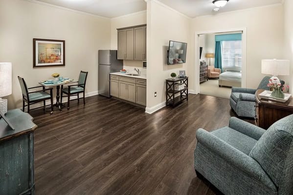 Interior view of a modern apartment featuring a kitchenette and living area.