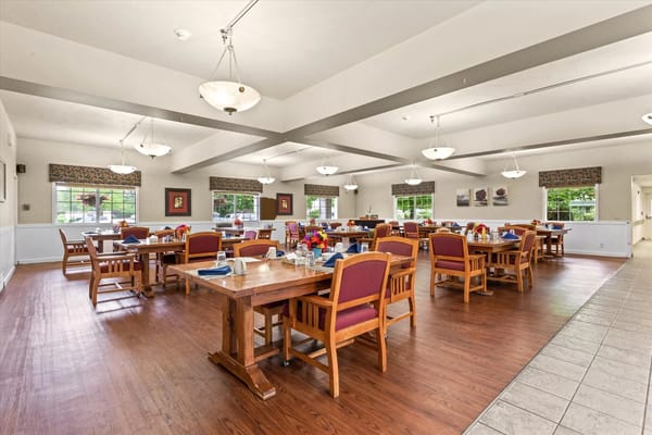 Spacious dining room with wooden tables and chairs, decorated for dining