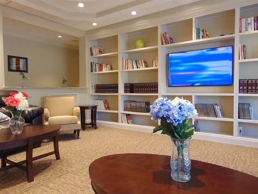 Cozy lounge area with bookshelves and flowers