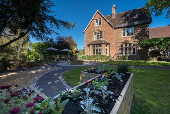 Exterior view of a senior living facility with a garden