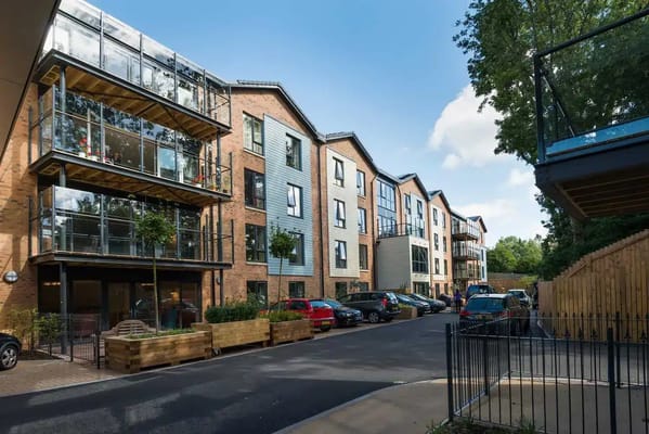 Exterior view of a senior living facility with landscaped gardens