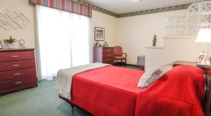 Cozy resident room with red bedding and furniture