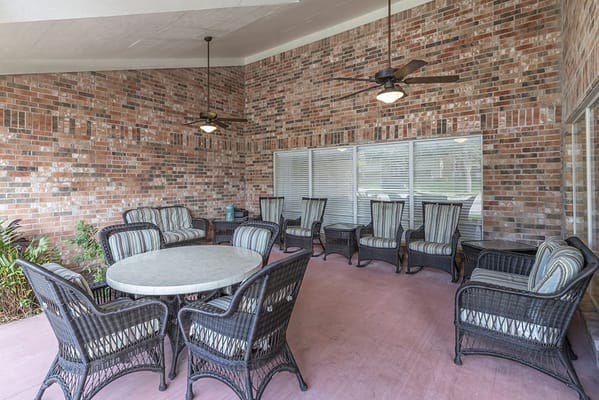 Outdoor seating area with wicker chairs and fans