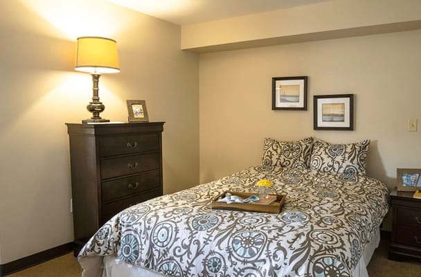 Cozy resident room featuring a bed and lamp