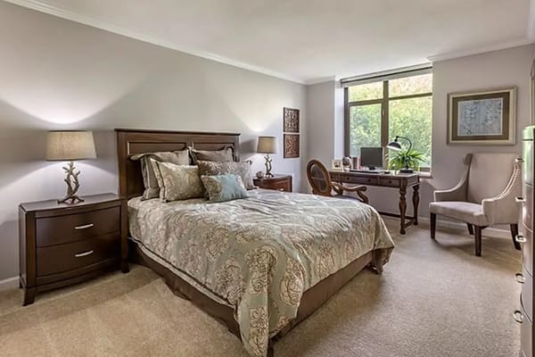 A cozy private resident room with a bed and desk