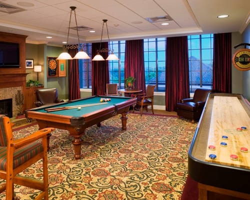 A game room with a pool table and dartboard