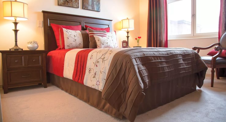 Cozy bedroom with decorative bedding and lamps