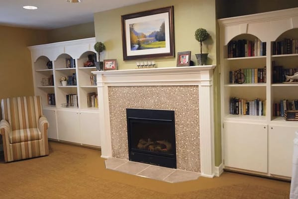Cozy common area with bookshelves and a fireplace