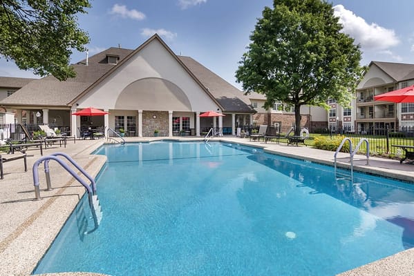Outdoor pool area with seating and umbrellas