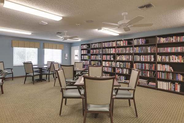 Interior view of a cozy library area with tables and bookshelves