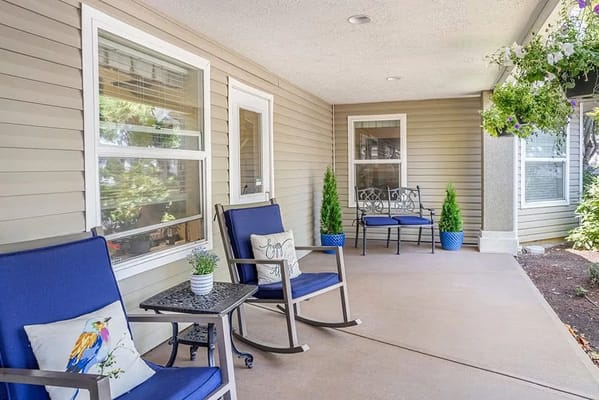 Outdoor seating area with rocking chairs and potted plants