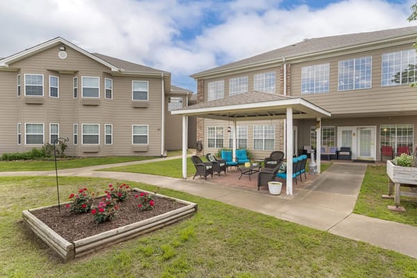 Outdoor seating area with colorful chairs and flower beds
