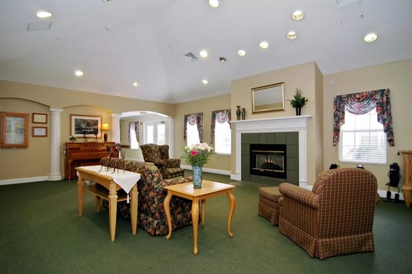 Common area with seating and fireplace in a senior living facility