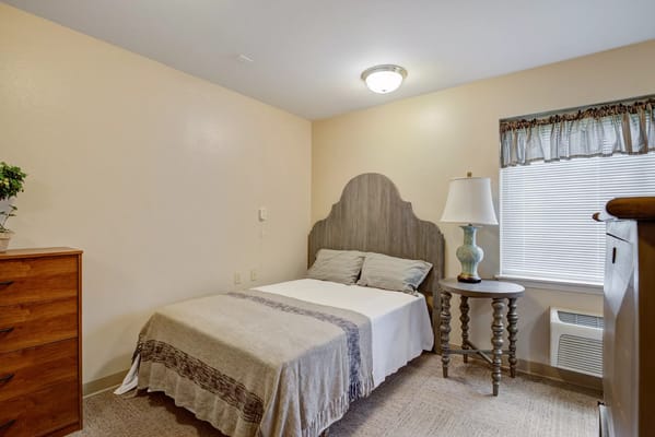 Cozy resident room with bed and dresser