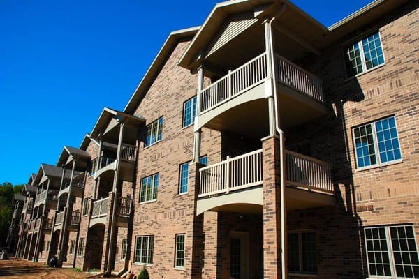 Exterior view of Brookview Meadows with balconies and brick facade.