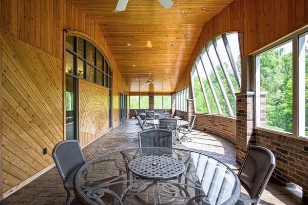 Bright sunroom with glass walls and seating