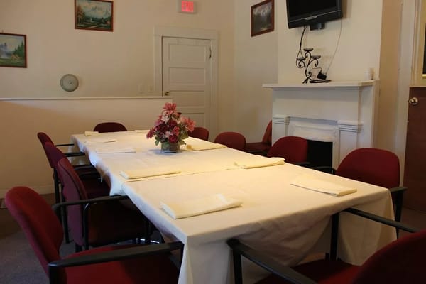 Dining room setup with empty chairs and a floral centerpiece