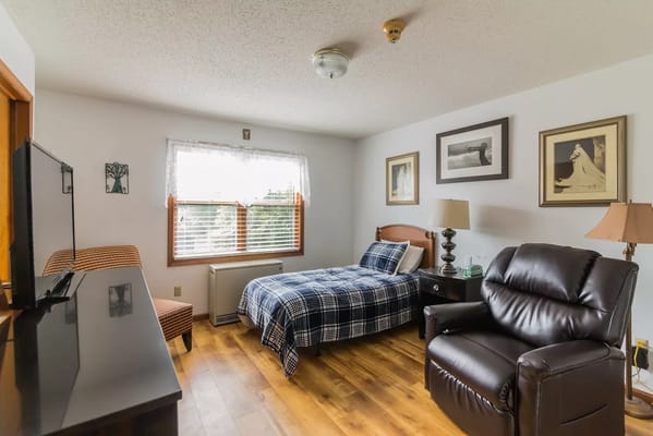 Comfortable bedroom with a bed, chair, and television