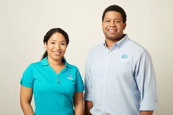 Two staff members smiling in uniform