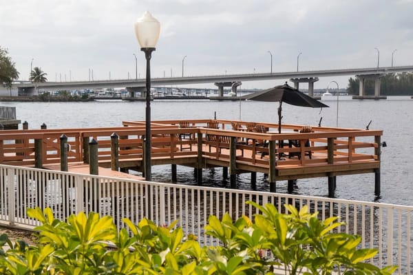 Wooden dock with seating and an umbrella overlooking the water