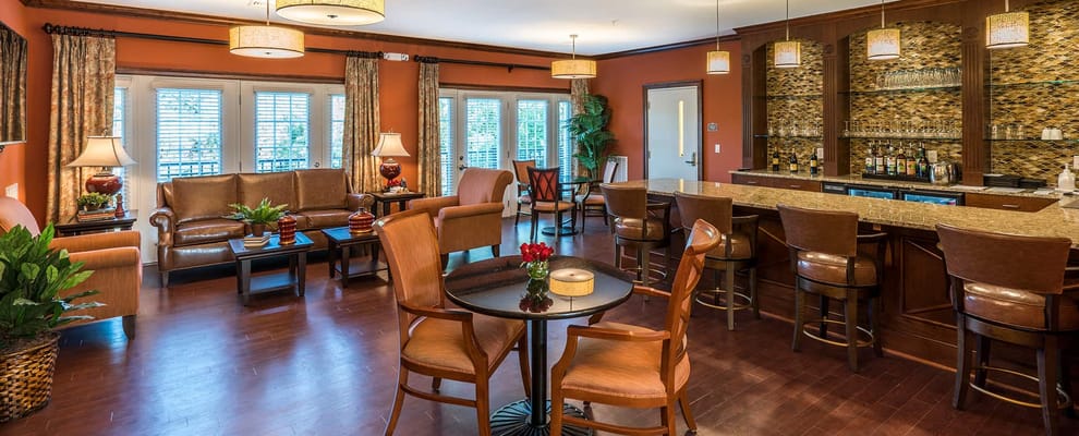 Bright common area with seating and a bar.
