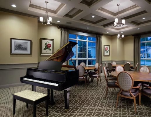 Common room featuring a grand piano and dining tables