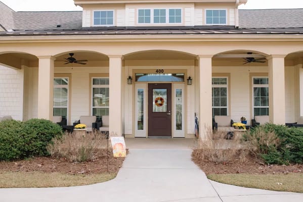 Front entrance of Camellia Place with seating and seasonal decor