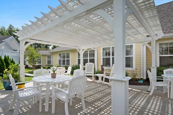Outdoor seating area with white chairs and a pergola