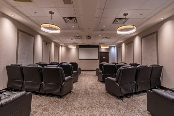 Interior view of a comfortable screening room with recliner seats