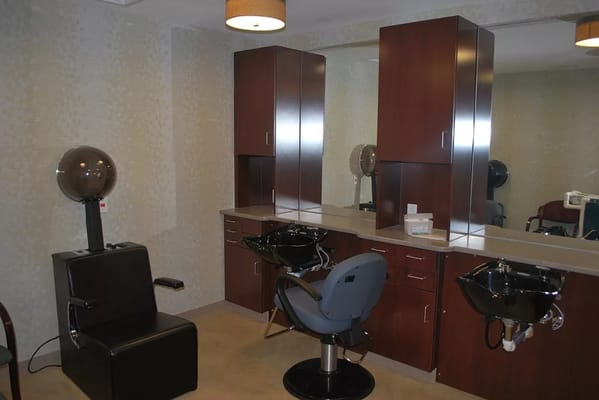 Interior of the salon featuring styling stations and hair dryers.