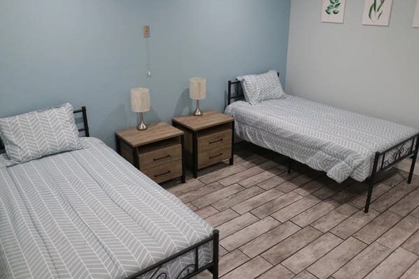 Two twin beds with nightstands in a well-lit room.