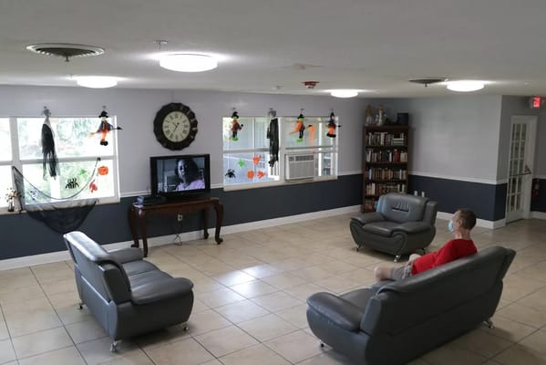 Resident watching TV in the lounge of Angel Care Assisted Living