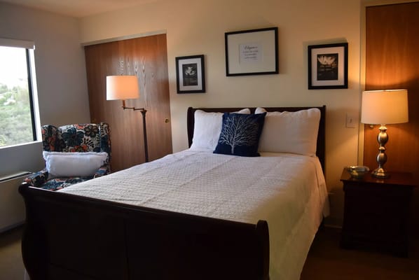 Well-decorated bedroom with a bed, chair, and lamp