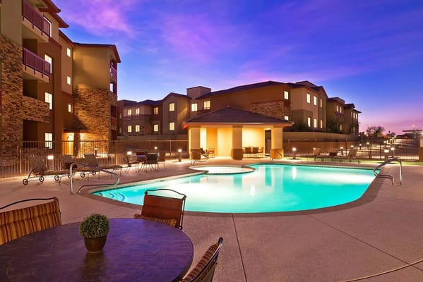 Pool area with lounge chairs at sunset