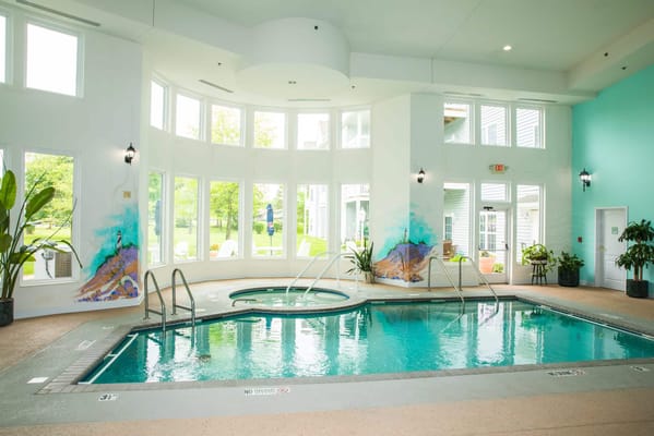 Indoor pool area with large windows and natural light