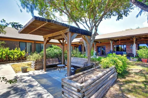 Wooden pavilion with benches and table in outdoor garden area