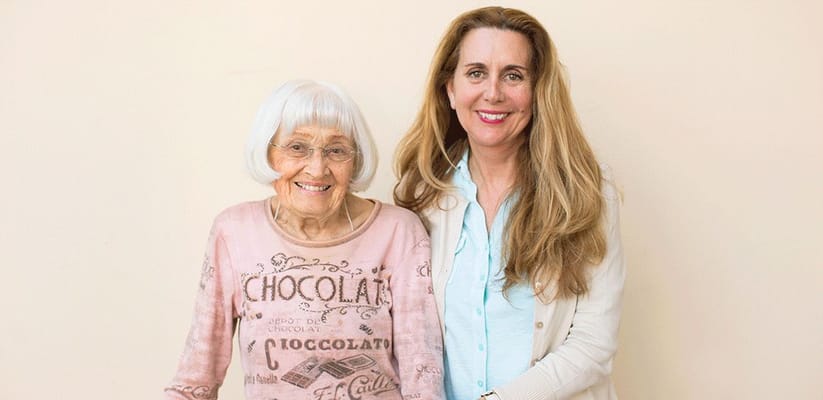 A resident and staff member smiling together