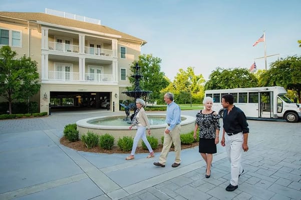 Residents walking near a fountain in front of the building