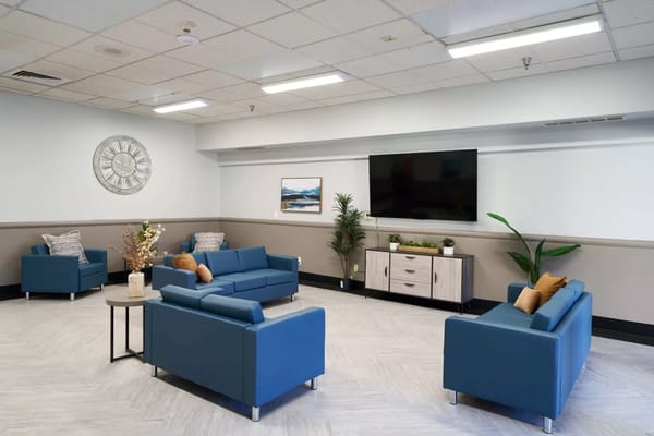 Bright common area with blue seating and plants
