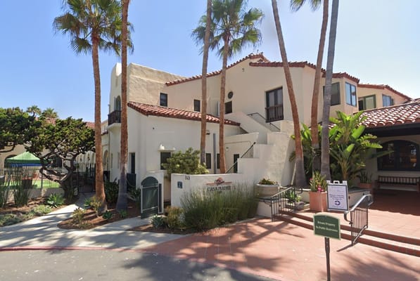 Exterior view of Casa de Mañana facility with palm trees