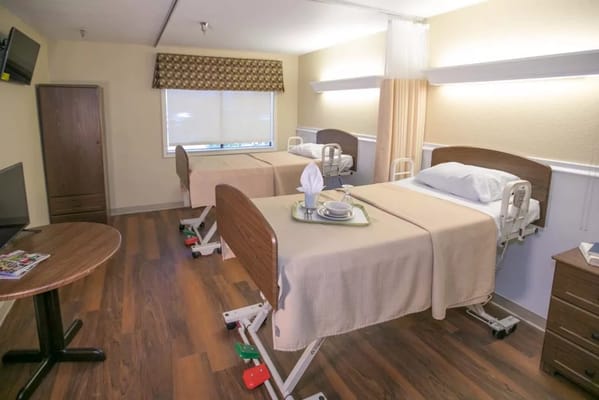 A well-furnished resident room with beds and amenities