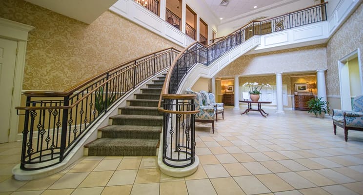 A well-lit interior lobby with a staircase and seating